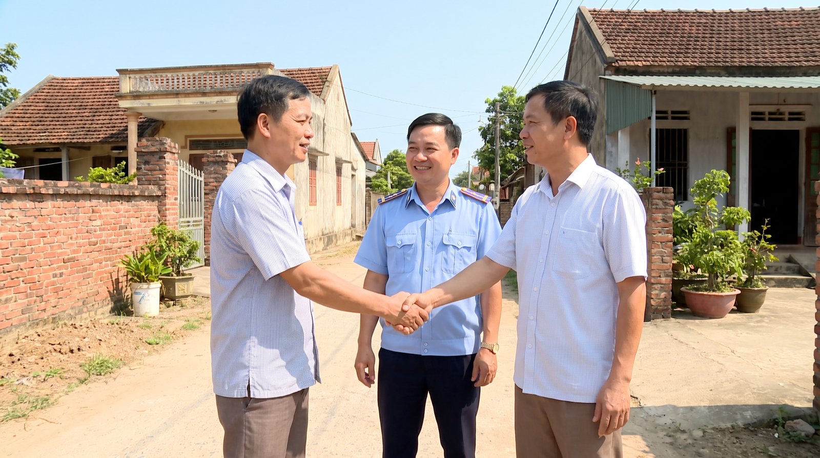 Hai người dân bắt tay hòa giải trước cán bộ xã
