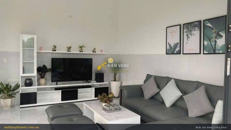Phòng khách nhà đất An Phước Long Thành 144 m², sofa da xám, TV, trần cao